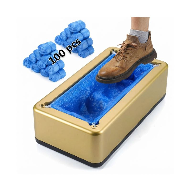Automatic shoe cover dispenser in gold finish loaded with blue disposable shoe covers, showing a shoe stepping into the machine.