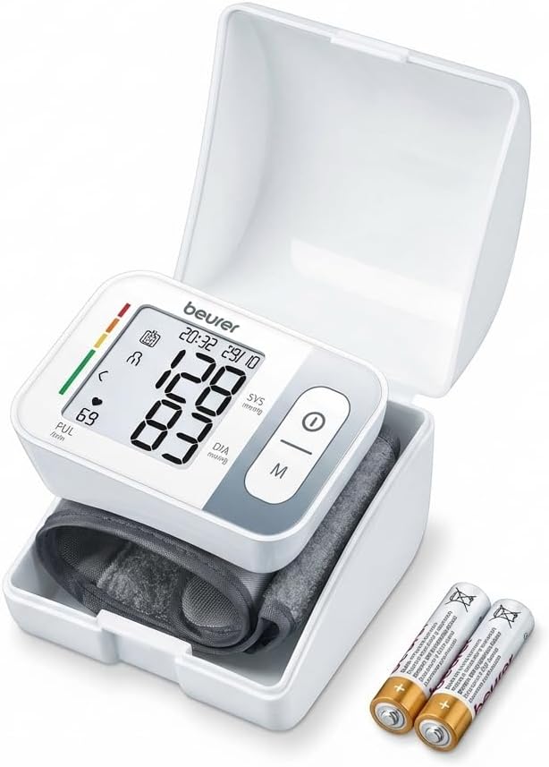 Beurer BC 28 automatic wrist blood pressure monitor displayed with its white protective storage case and two AAA batteries.