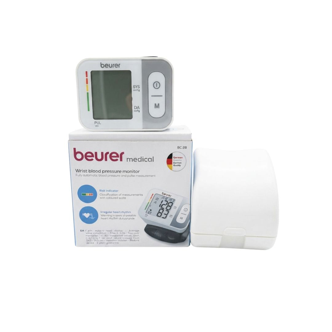 Beurer BC 28 digital wrist blood pressure monitor resting on top of its branded retail box alongside its portable white protective storage case.