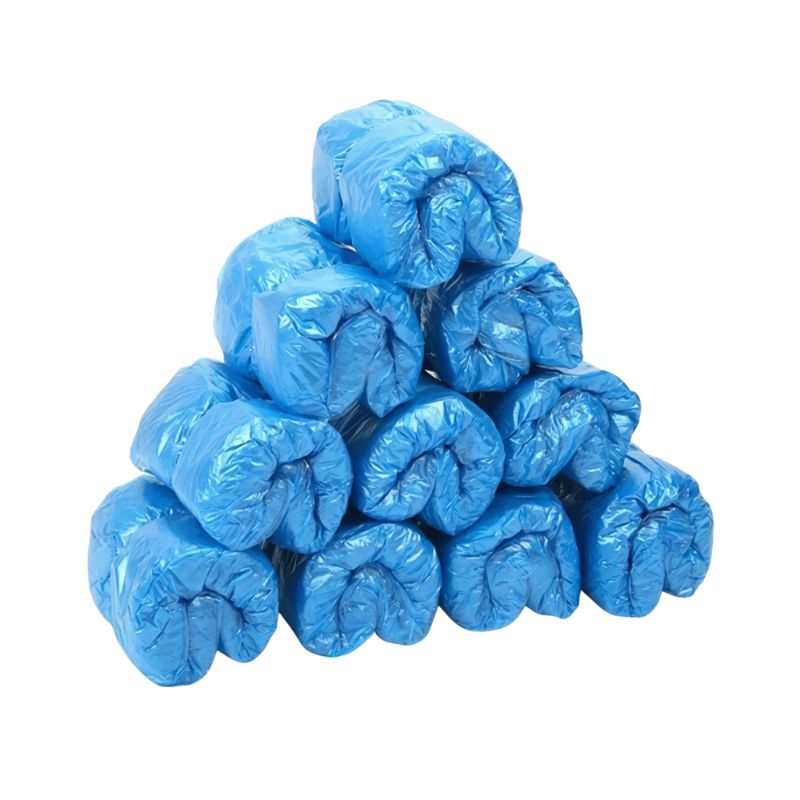 Neat pyramid stack of rolled blue disposable shoe covers ready for loading into a shoe cover machine.