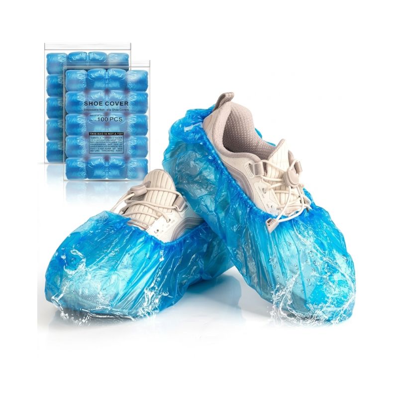Water-resistant shoe cover for dispenser displayed with 100pcs packaging bags and sneakers featuring a protective water splash effect.